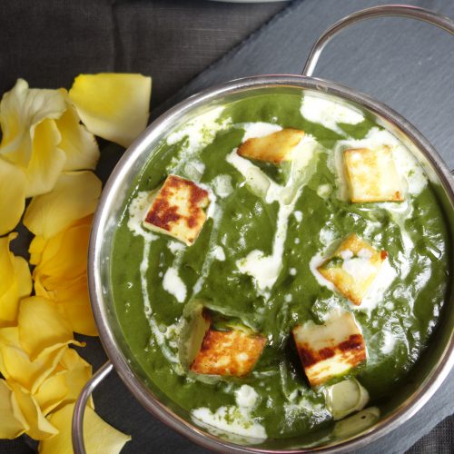palak paneer with a swirl of cream in a kadhai