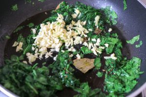 Adding chopped spinach and ginger garlic to the tempering