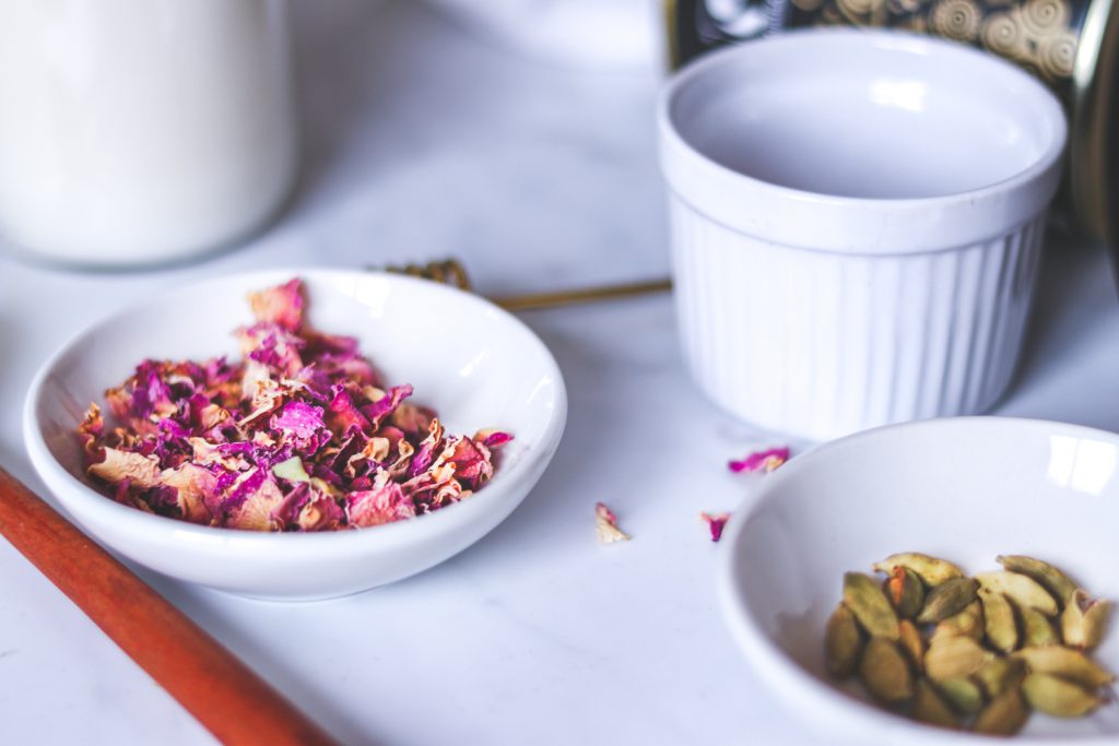 rose petals and cardamoms in white bowls