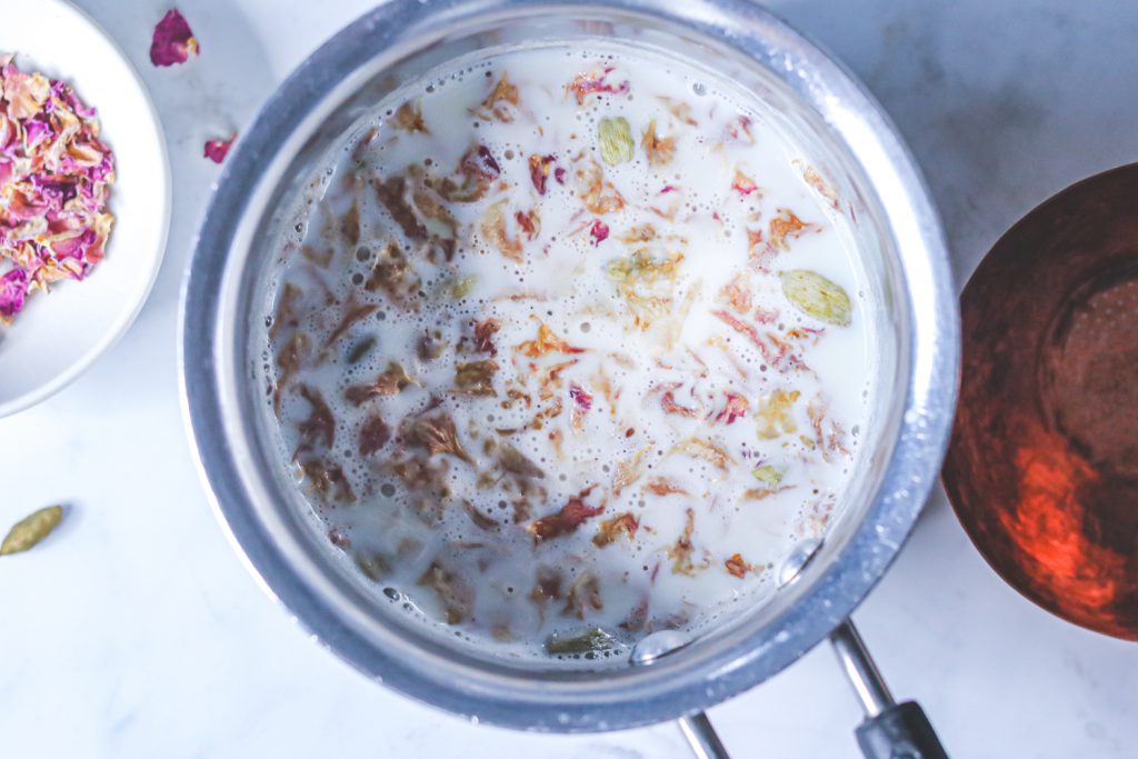 Milk infused with rose petals and cardamoms in a pan