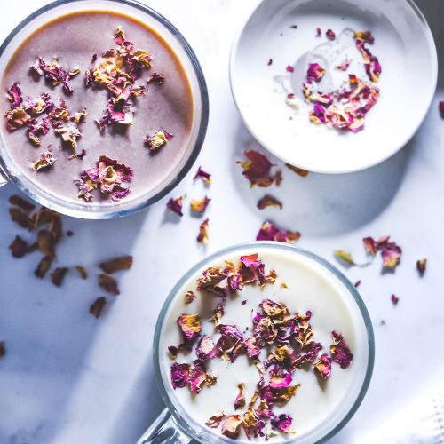 hot chocolates in mugs garnished with rose petals