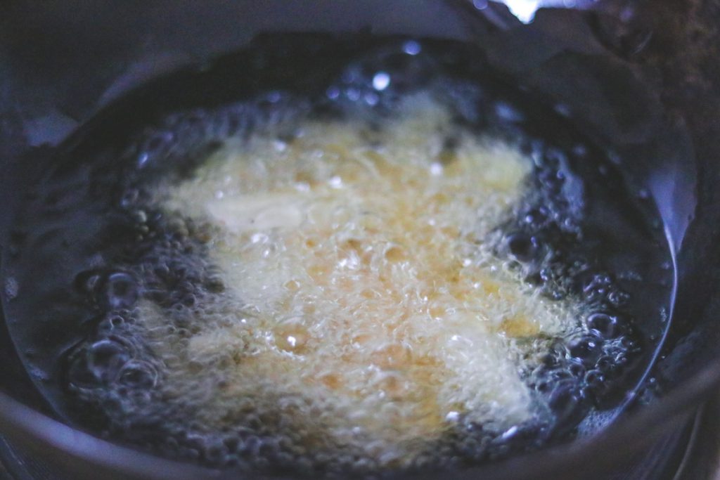 Deep frying arbi slices in a kadhai