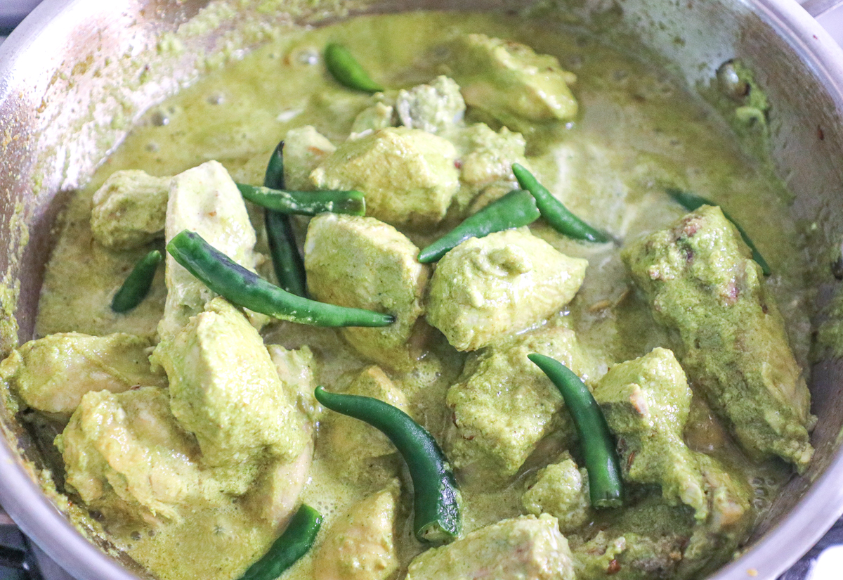 whole green chillies on chicken being cooked