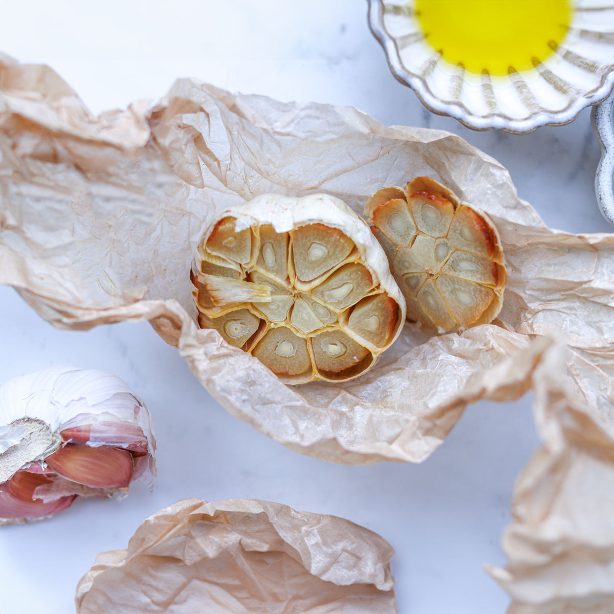 Roasted garlic in the parchment paper on white background
